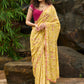 Graceful yellow floral print saree highlighted with overall beautiful hand embroidered mirrors