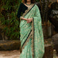 Elegant Emerald green floral printed saree highlighted with bottle green velvet & contrast scalloped lace