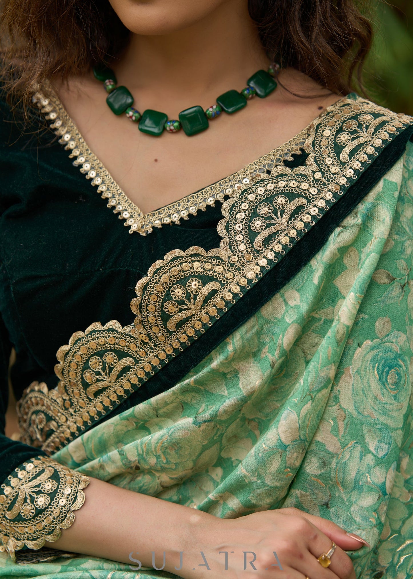 Elegant Emerald green floral printed saree highlighted with bottle green velvet & contrast scalloped lace