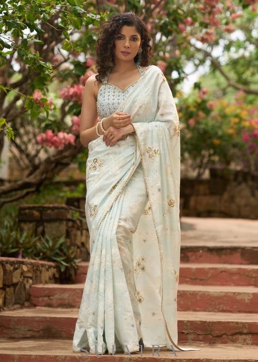 Stylish ice blue floral printed saree highlighted with beautiful golden embroidery