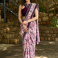 Gracious purple floral printed saree highlighted with velvet pearl embroidered border