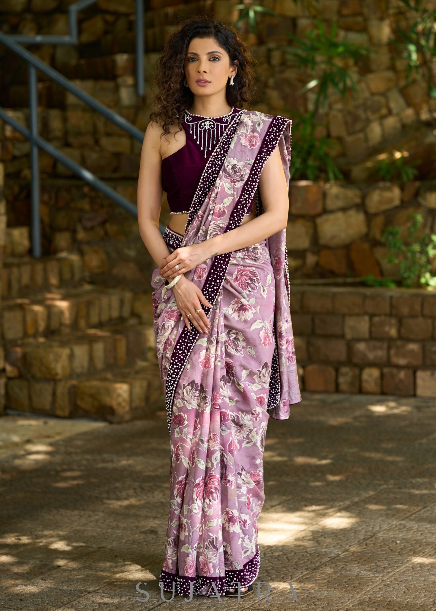 Gracious purple floral printed saree highlighted with velvet pearl embroidered border