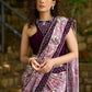 Gracious purple floral printed saree highlighted with velvet pearl embroidered border