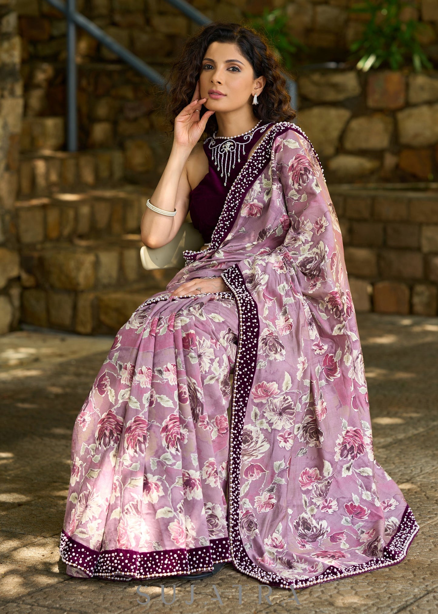 Gracious purple floral printed saree highlighted with velvet pearl embroidered border