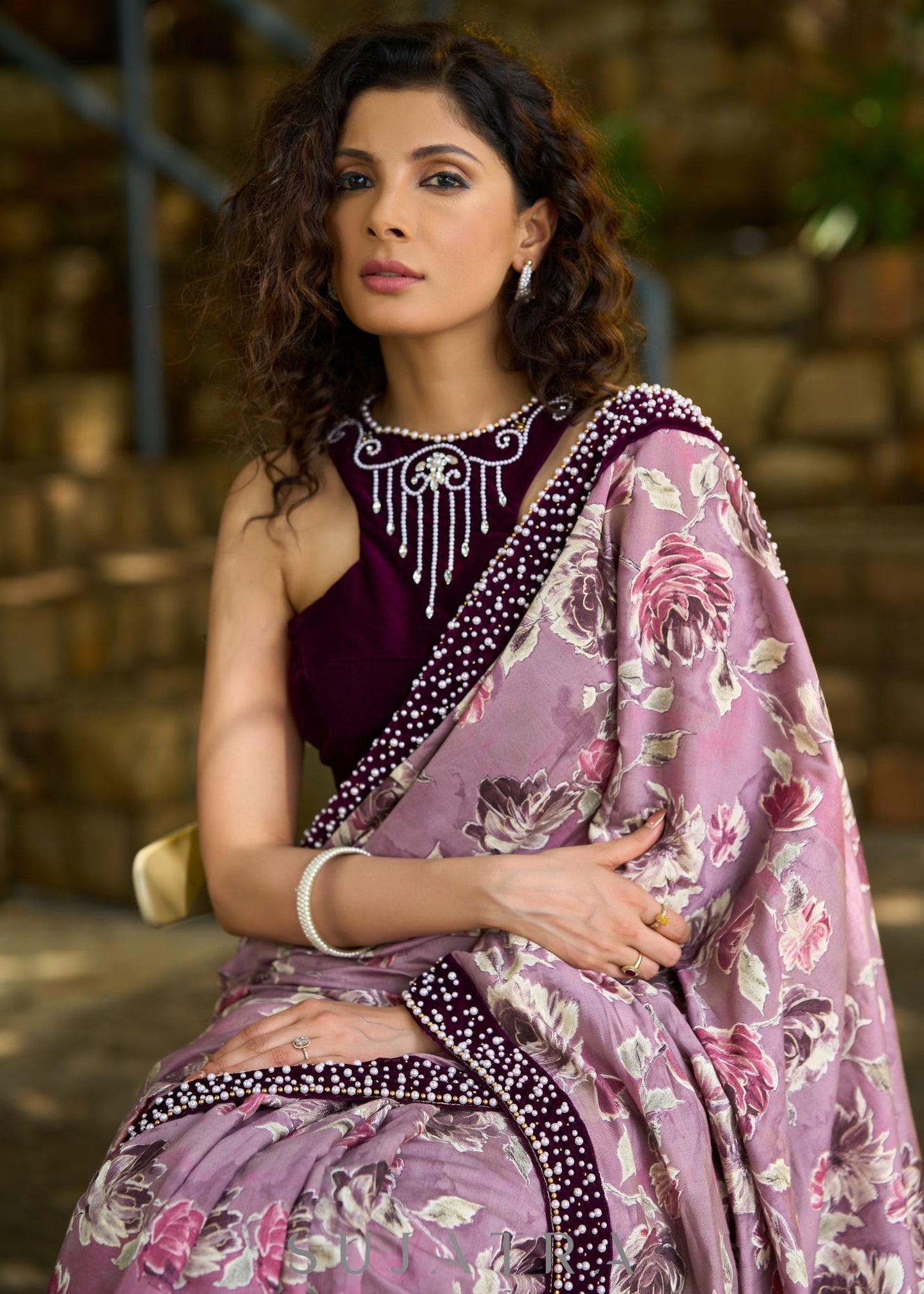 Gracious purple floral printed saree highlighted with velvet pearl embroidered border