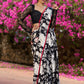 Trendy black floral printed cotton saree highlighted with overall bead embroidery