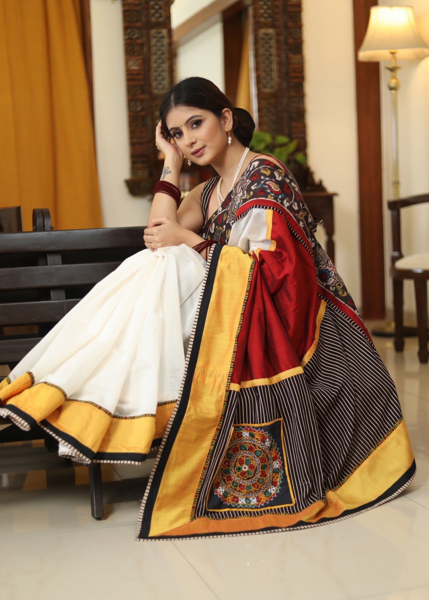 Smart white Chanderi saree with exclusive Kalamkari hand painted border and maroon Pallu with mirror work