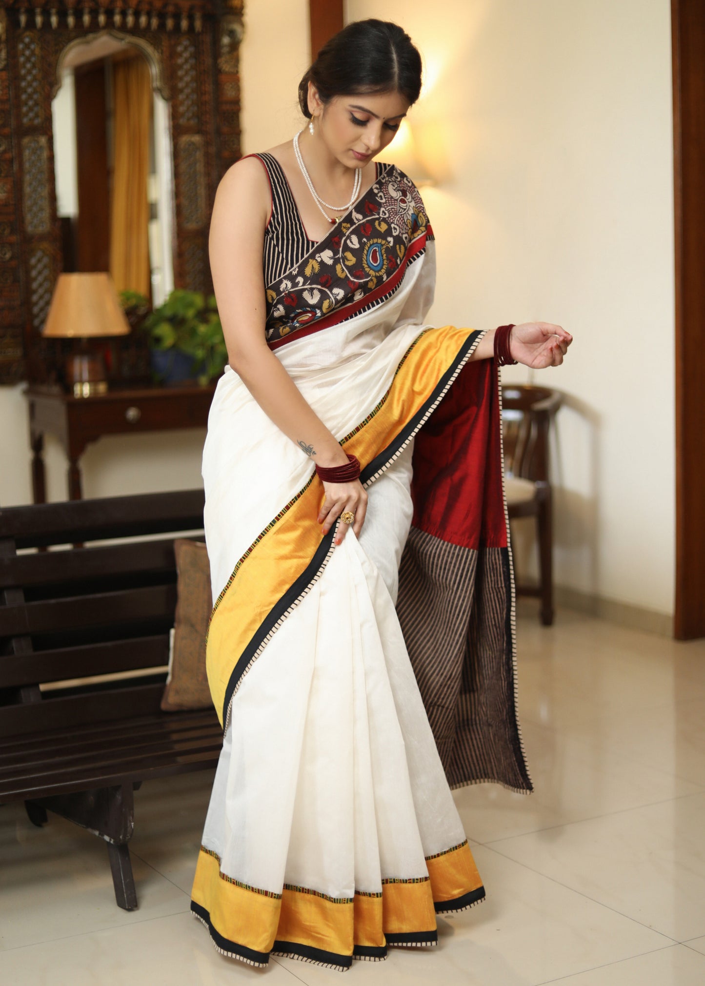 Smart white Chanderi saree with exclusive Kalamkari hand painted border and maroon Pallu with mirror work