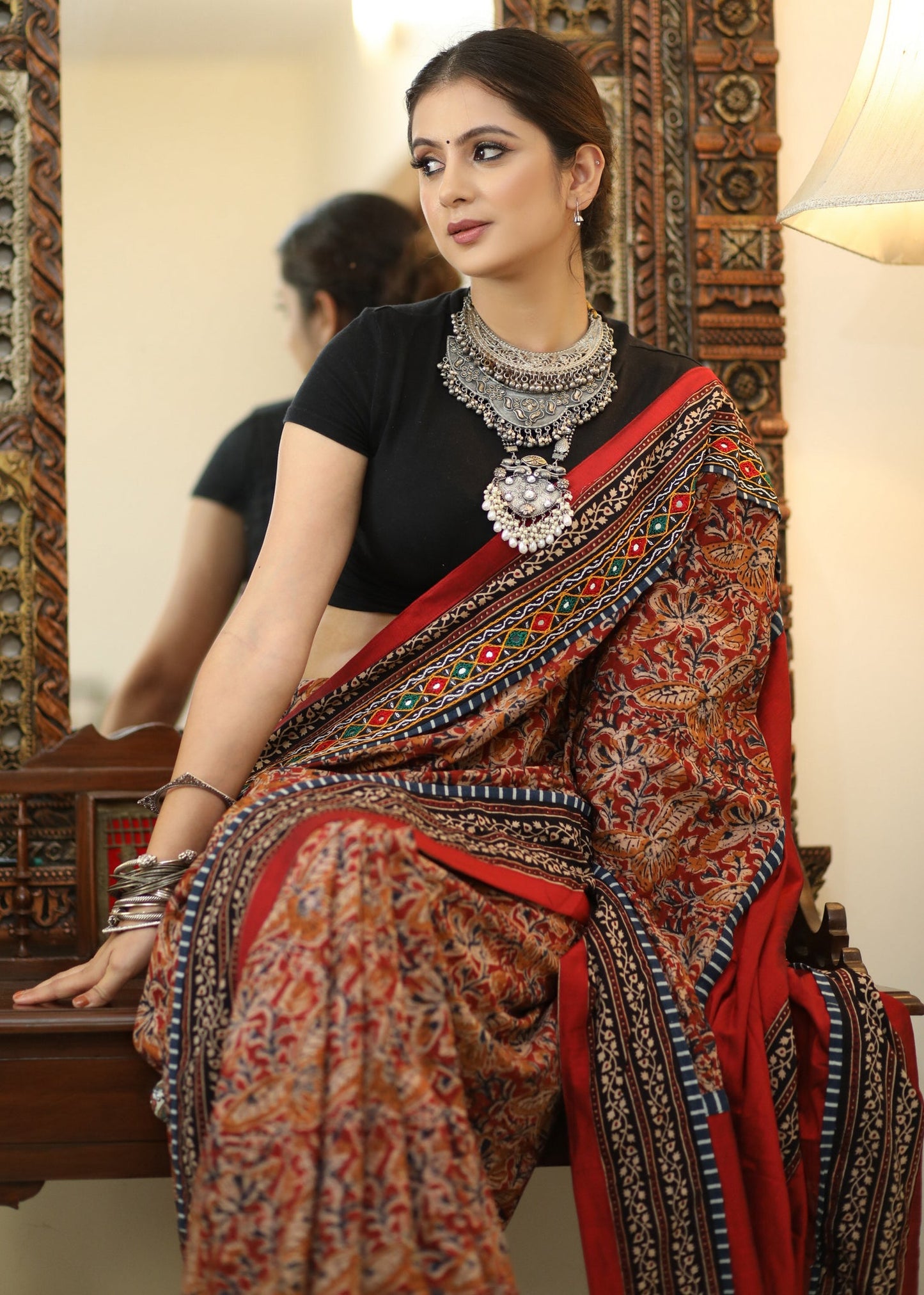 Stylish Cotton Kalamkari print saree with mirrorwork and Ajrakh border.