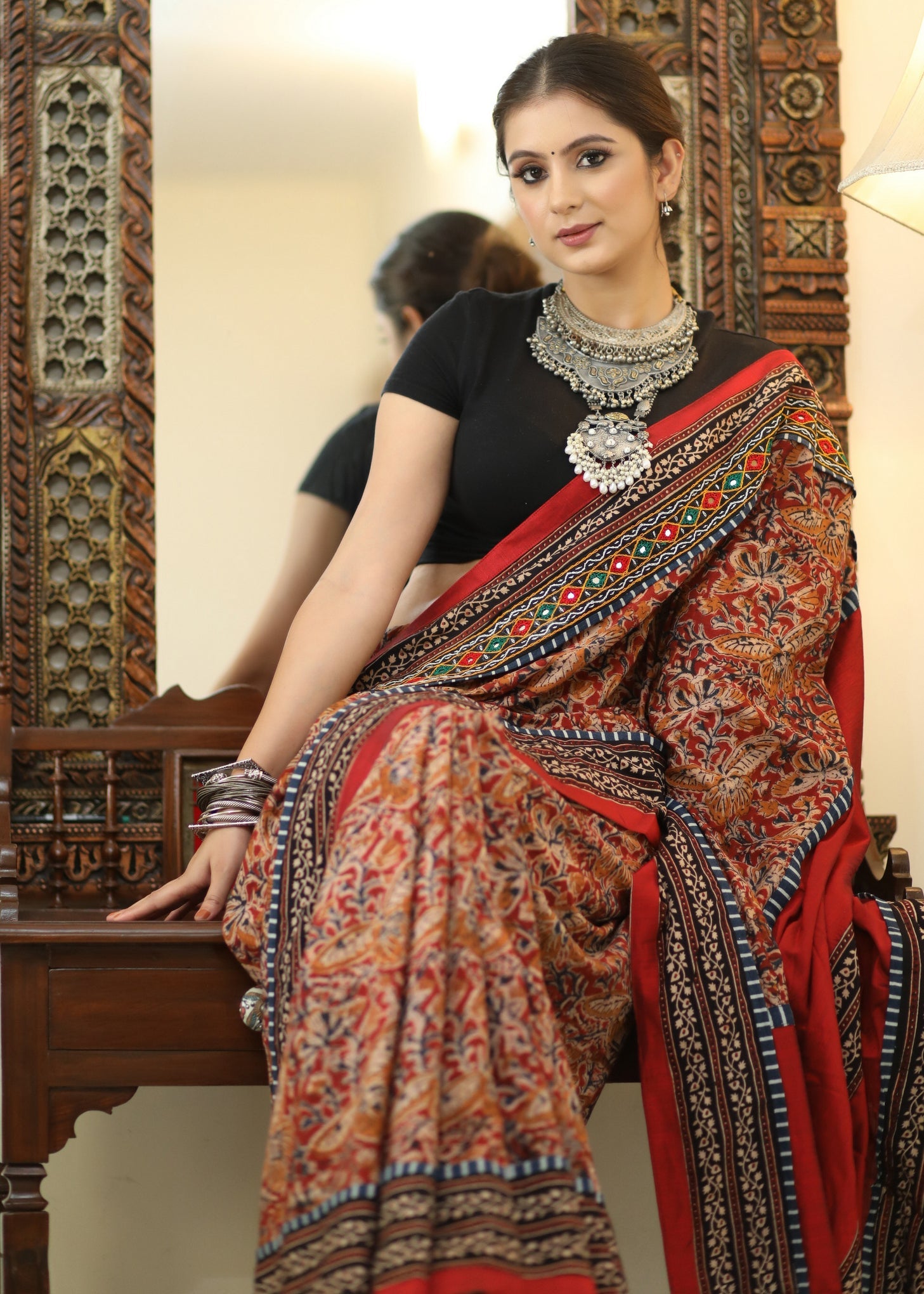 Stylish Cotton Kalamkari print saree with mirrorwork and Ajrakh border.